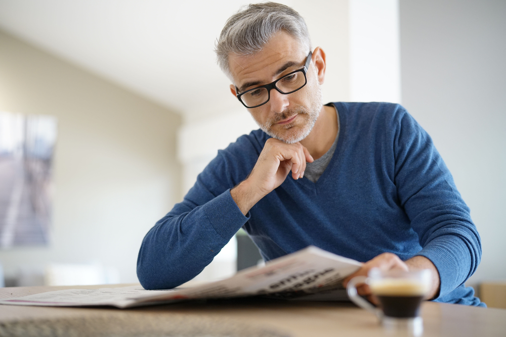 Middle-aged,Man,At,Home,Drinking,Coffee,And,Reading,Newspaper